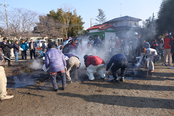 辻集落火渉 薪を拾う参拝者 [2015年2月11日撮影]